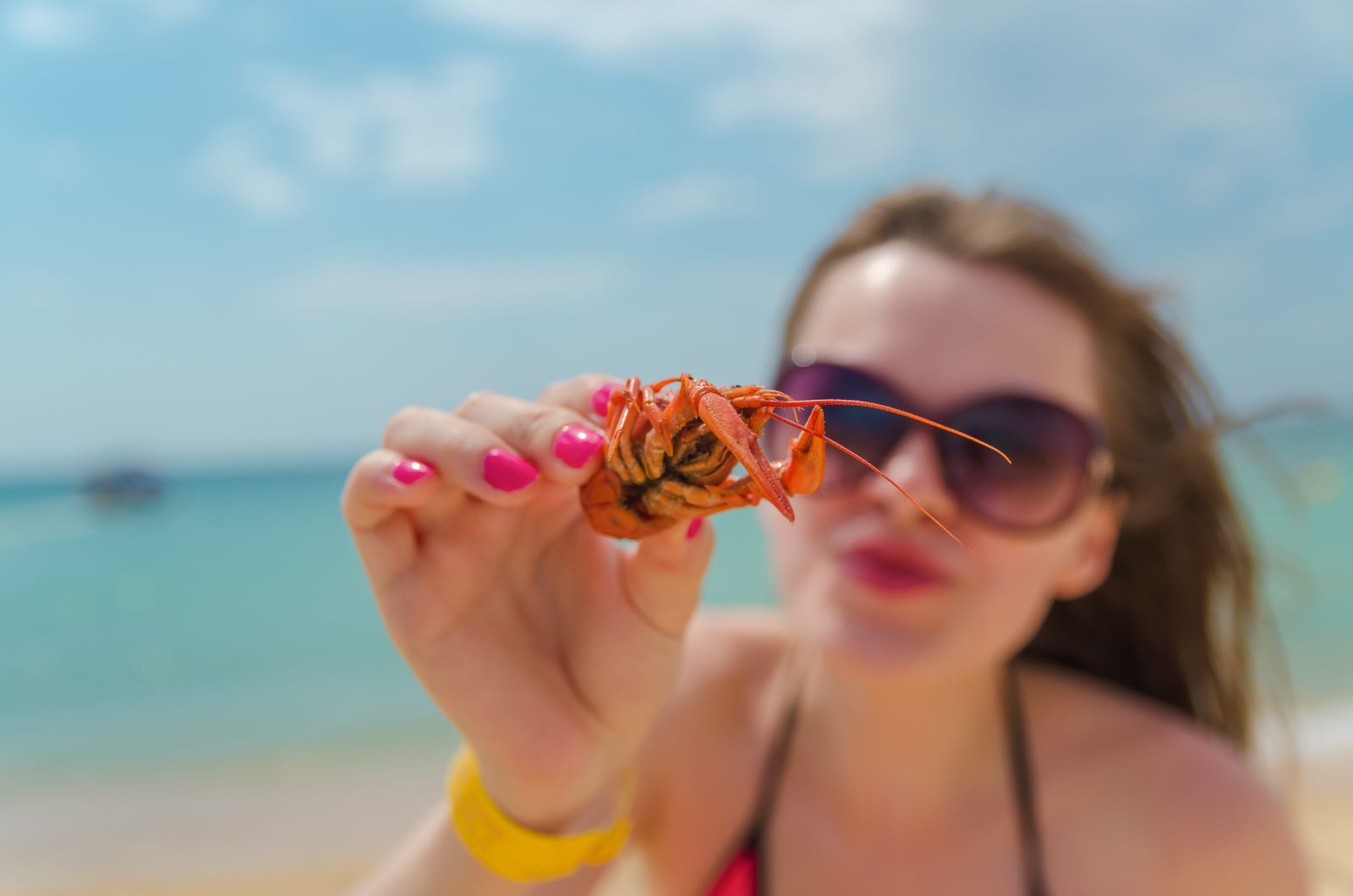 women with lobster on the beach